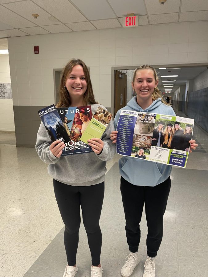 Seniors Morgan Crawford and Emma Shook display some of the informative literature found in the school counseling office.